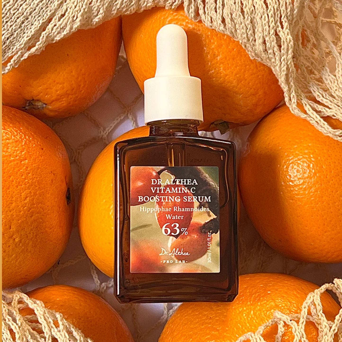 Dr. Althea Vitamin C Boosting Serum bottle surrounded by oranges – brightening vitamin-rich skincare