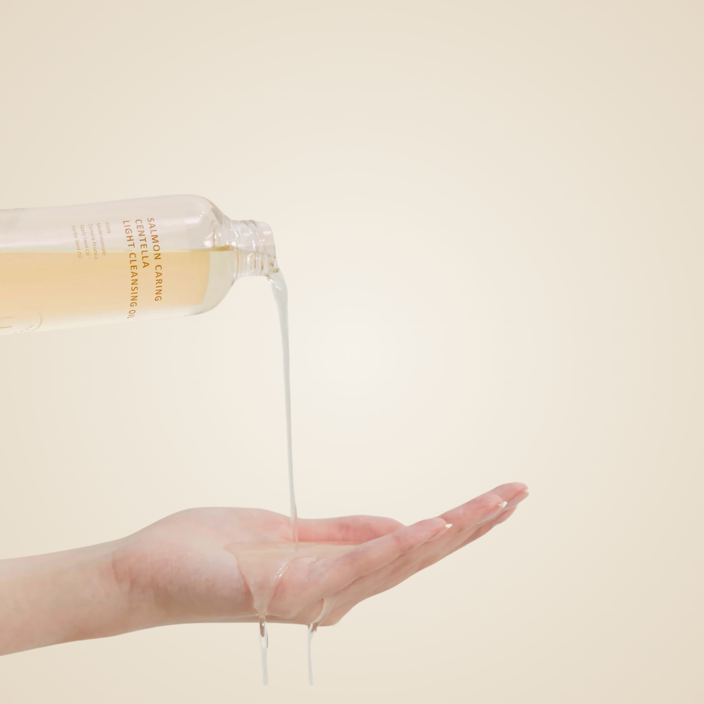 Heveblue Salmon Caring Centella Light Cleansing Oil poured into hand – silky oil cleanser for deep yet gentle cleansing.