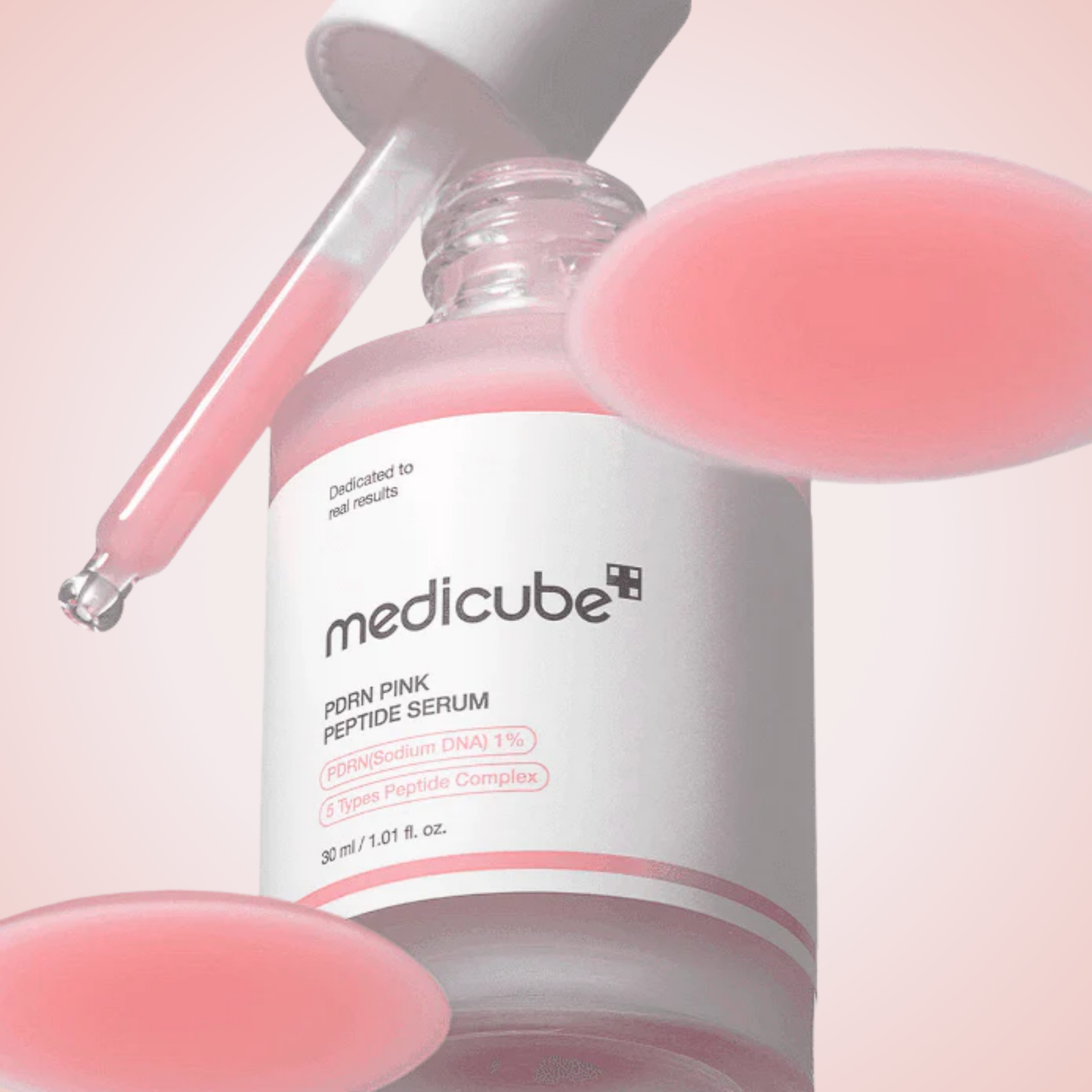 Close-up of medicube PDRN Pink Peptide Serum dropper with pink peptide-rich formula.