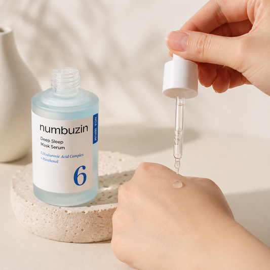 Numbuzin No.6 Deep Sleep Mask Serum 50ml being applied onto the hand with a glass dropper, showing the lightweight hydrating serum texture in soft natural light.