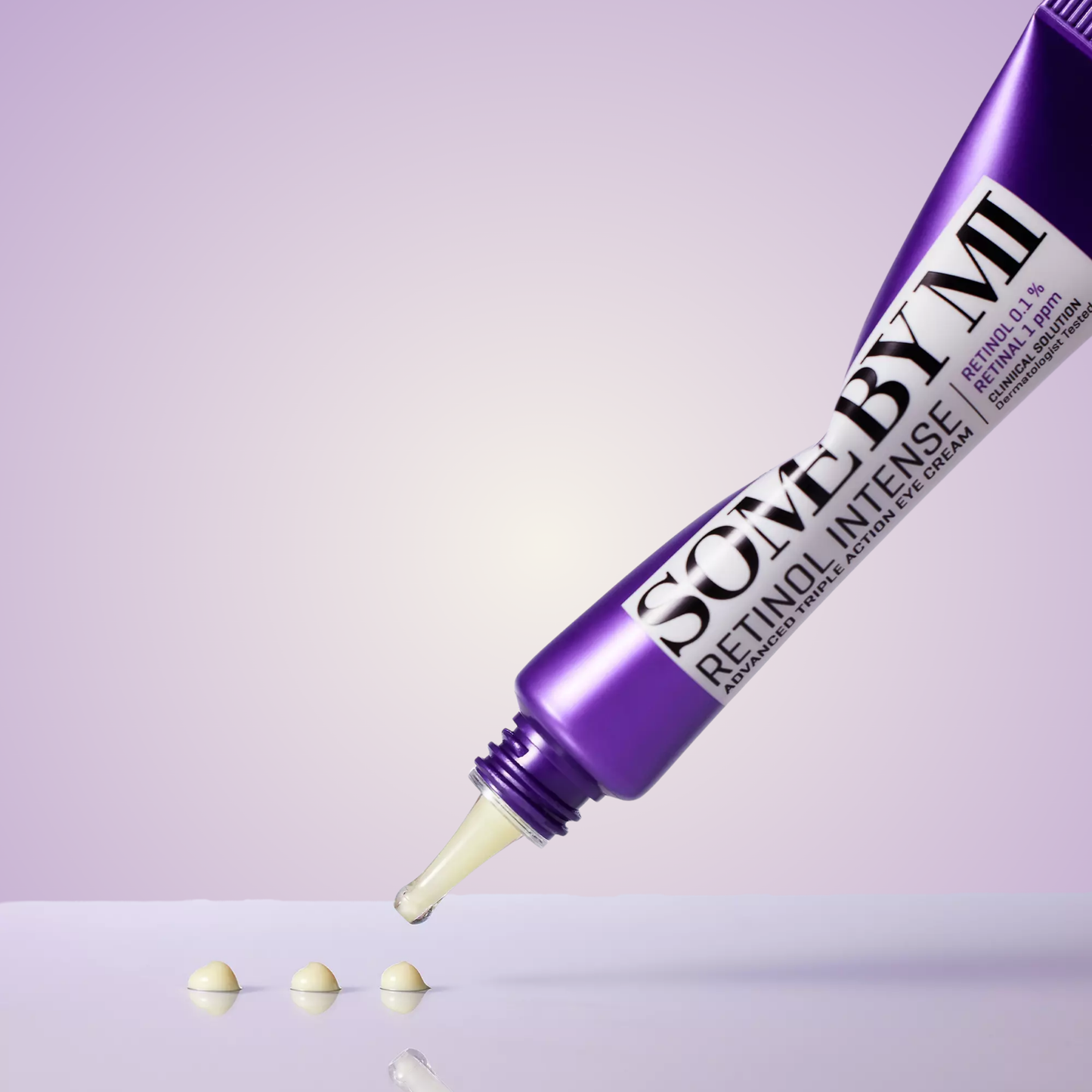 Close-up of SOME BY MI Retinol Intense Eye Cream tube and drops of product on light surface