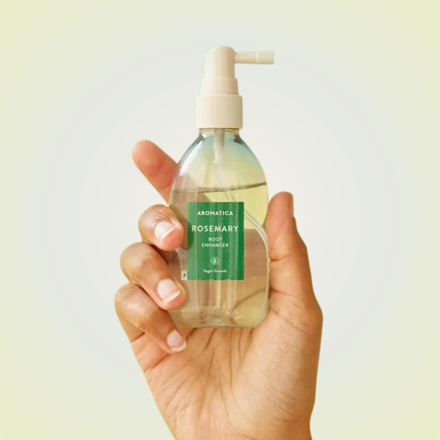 Applying Aromatica Rosemary Root Enhancer on scalp – refreshing mist for strengthening roots and promoting growth