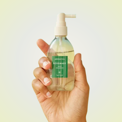 Applying Aromatica Rosemary Root Enhancer on scalp – refreshing mist for strengthening roots and promoting growth