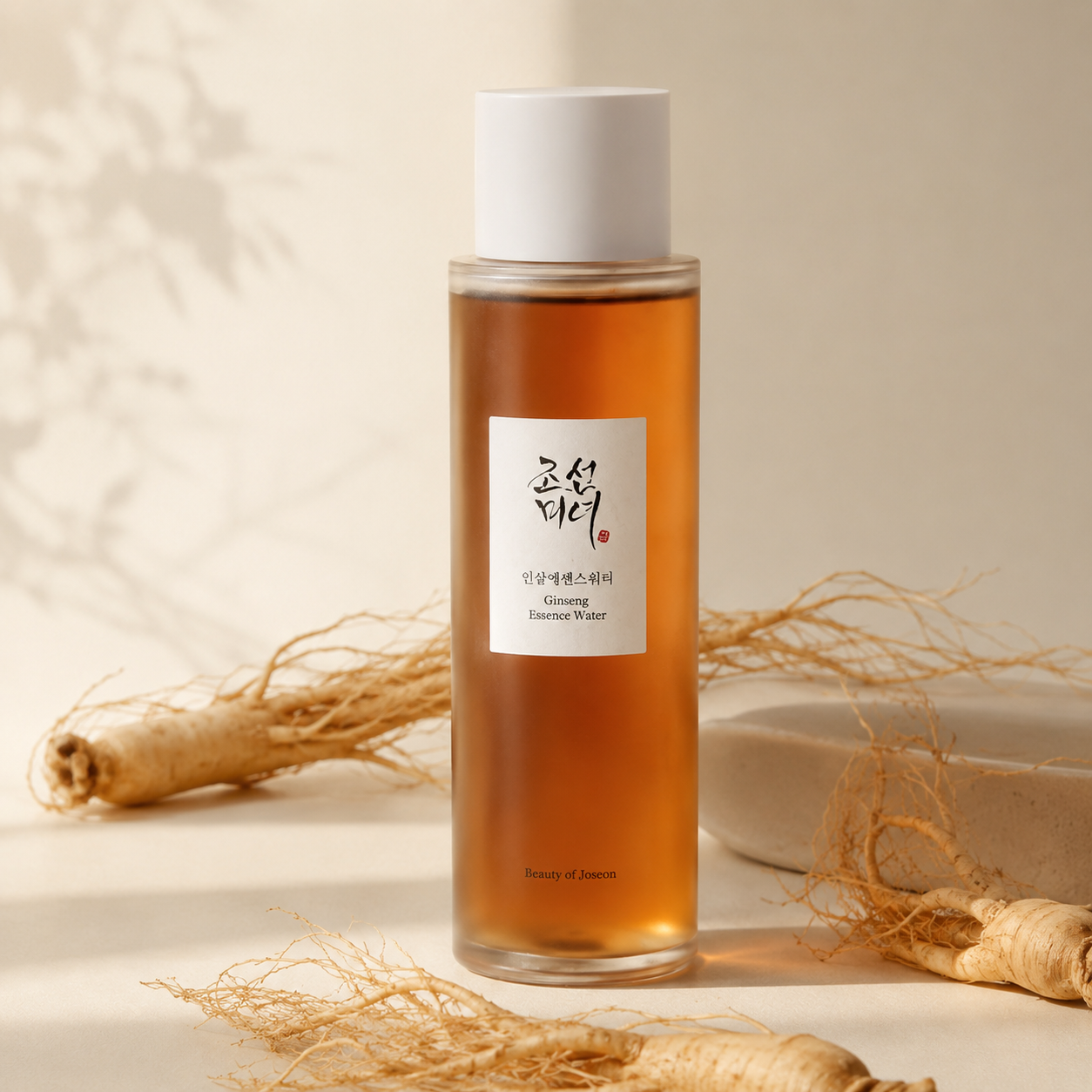 Beauty of Joseon Ginseng Essence Water 150ml styled with ginseng roots on a warm neutral surface, highlighting its ginseng-infused skincare formula.