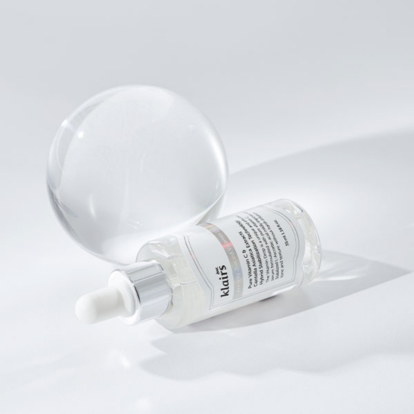 Dear, Klairs Freshly Juiced Vitamin Drop displayed on glass surface with glowing finish
