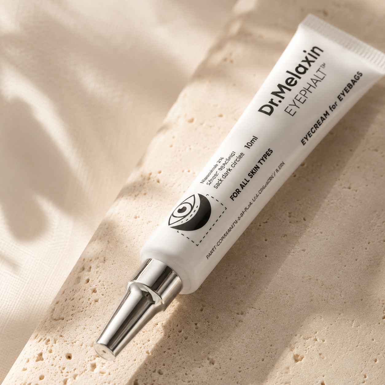 Macro close-up of Dr. Melaxin Eyephalt Eyebag Cream 10ml highlighting the precision applicator tip, premium packaging details, and crisp typography with soft natural lighting.