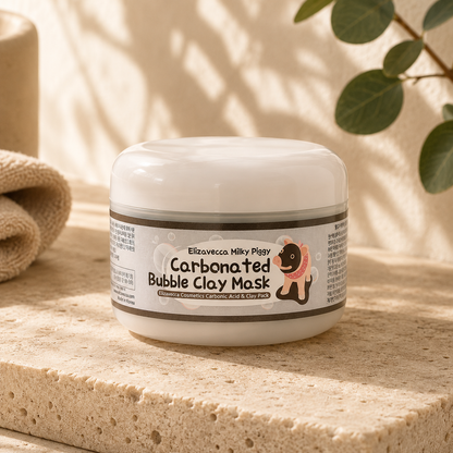 Elizavecca Milky Piggy Carbonated Bubble Clay Mask displayed on warm beige travertine under soft morning sunlight with delicate botanical shadows, showcasing the original jar packaging in a premium Korean skincare editorial hero photograph with a calm, minimalist luxury aesthetic.