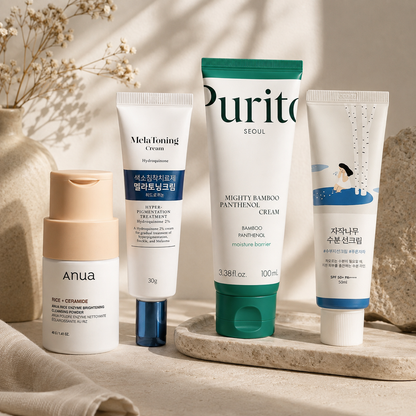 Anua Rice Enzyme Cleansing Powder, Dong-A Pharm Melatoning Cream, Purito Mighty Bamboo Panthenol Cream, and Round Lab Birch Juice Sunscreen styled in a warm editorial skincare setting.