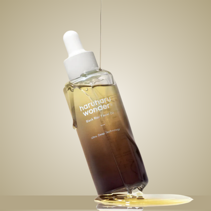 haruharu wonder Black Rice Facial Oil bottle tilted with golden oil reflection