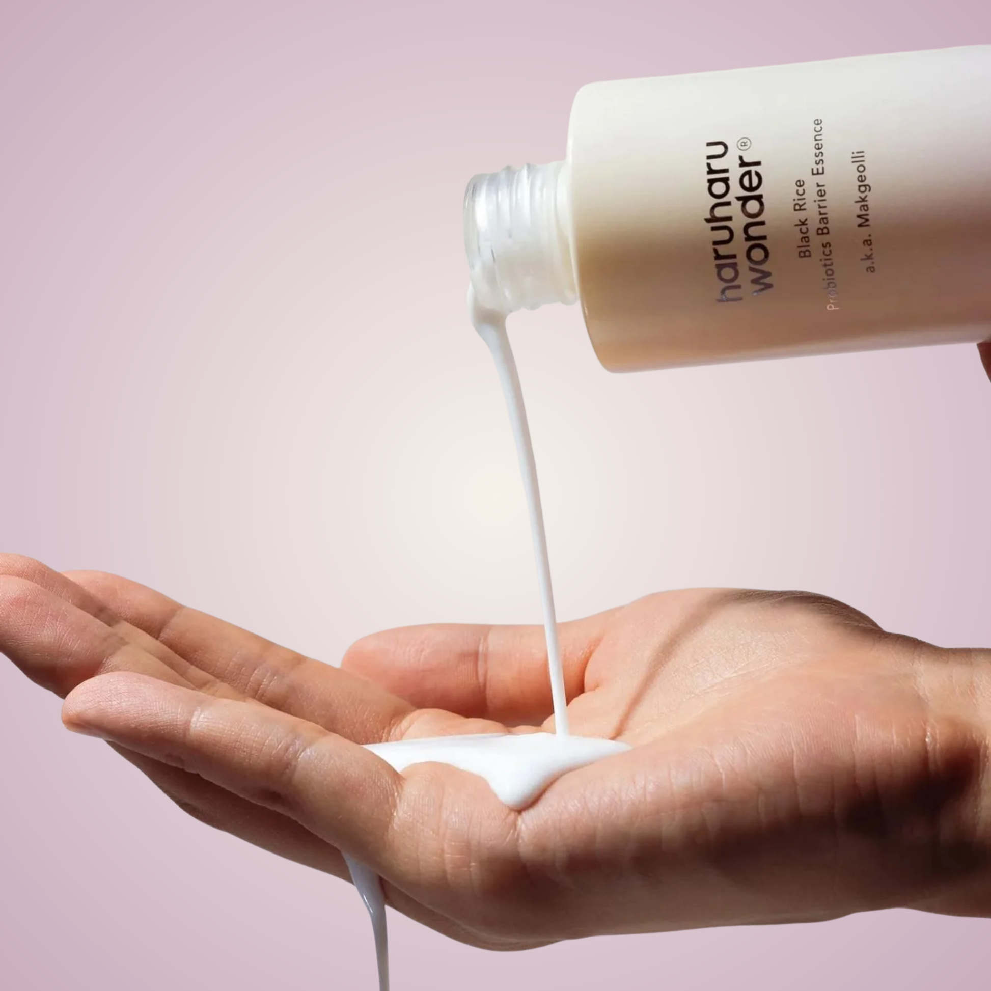 Applying haruharu wonder Black Rice Probiotics Barrier Essence on hands – lightweight brightening essence for resilient, glowing skin