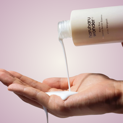 Applying haruharu wonder Black Rice Probiotics Barrier Essence on hands – lightweight brightening essence for resilient, glowing skin