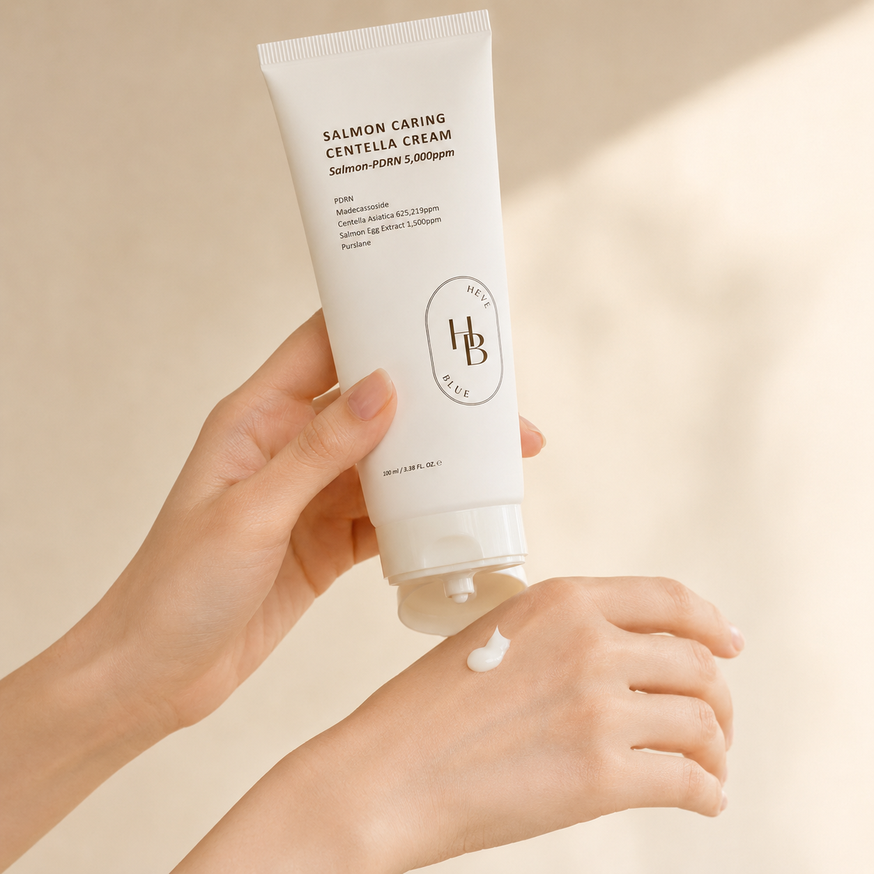 Heveblue Salmon Caring Centella Cream 100ml being applied onto the hand in soft natural light, showing the creamy texture in a calm Korean skincare routine moment.
