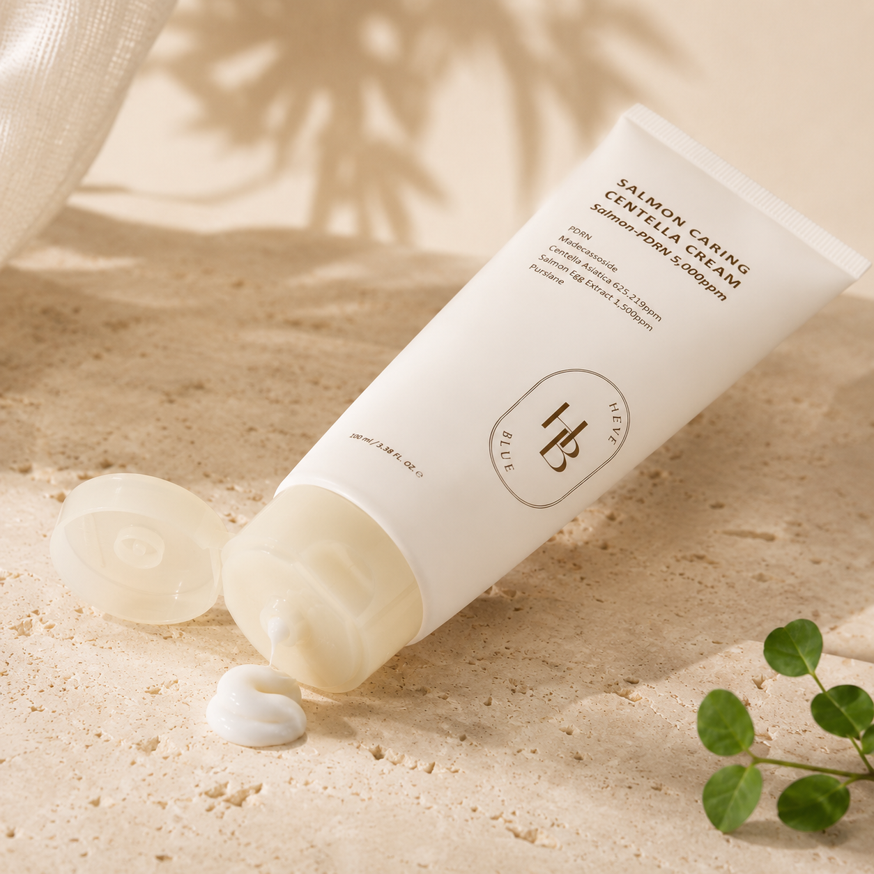 Heveblue Salmon Caring Centella Cream 100ml shown opened with a smooth white cream texture dispensed onto warm stone in a luxury skincare texture photo.