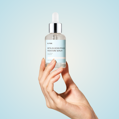 Hand holding iUNIK Beta-Glucan Power Moisture Serum 50ml with dropper cap