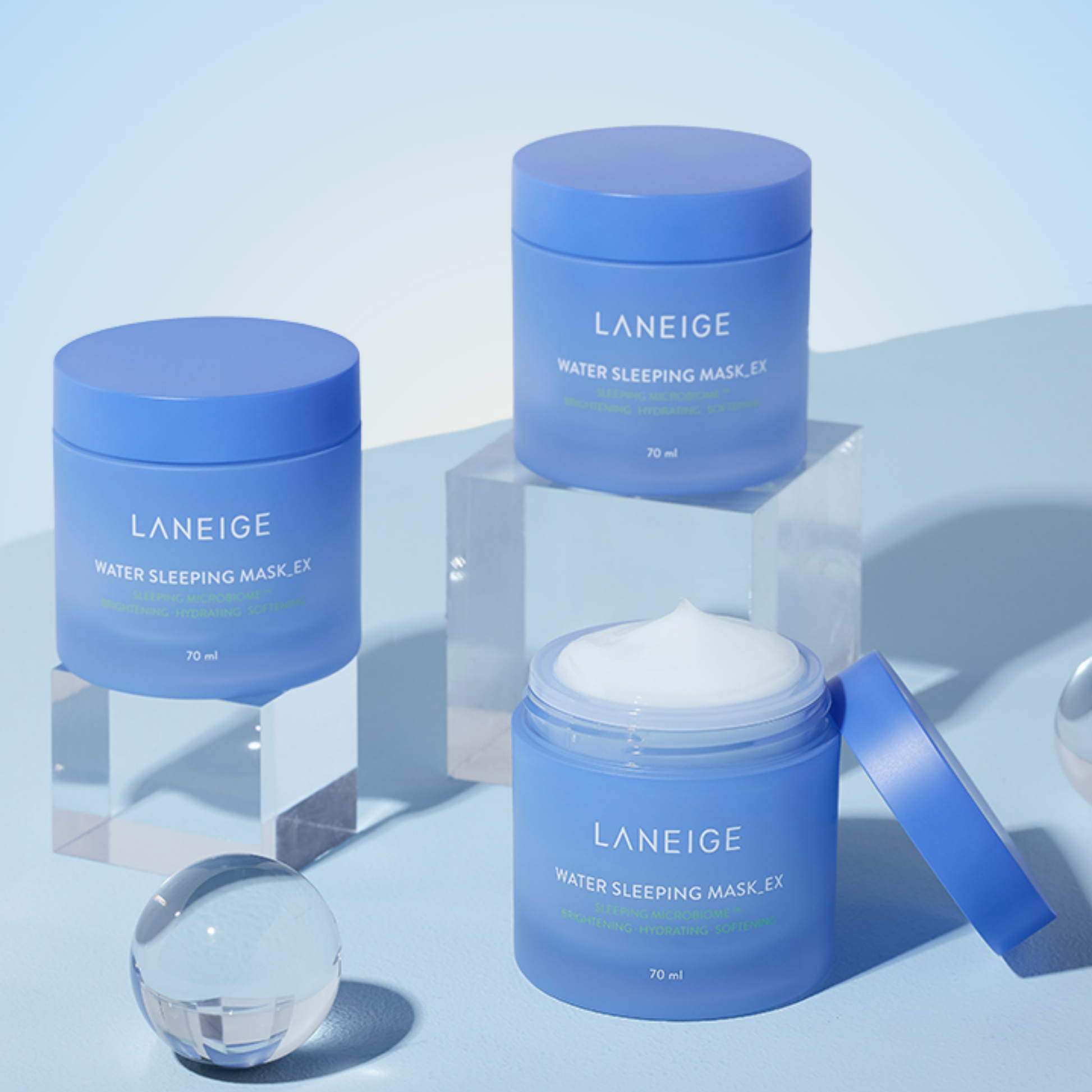 LANEIGE Water Sleeping Mask EX displayed with skincare set and props on blue background