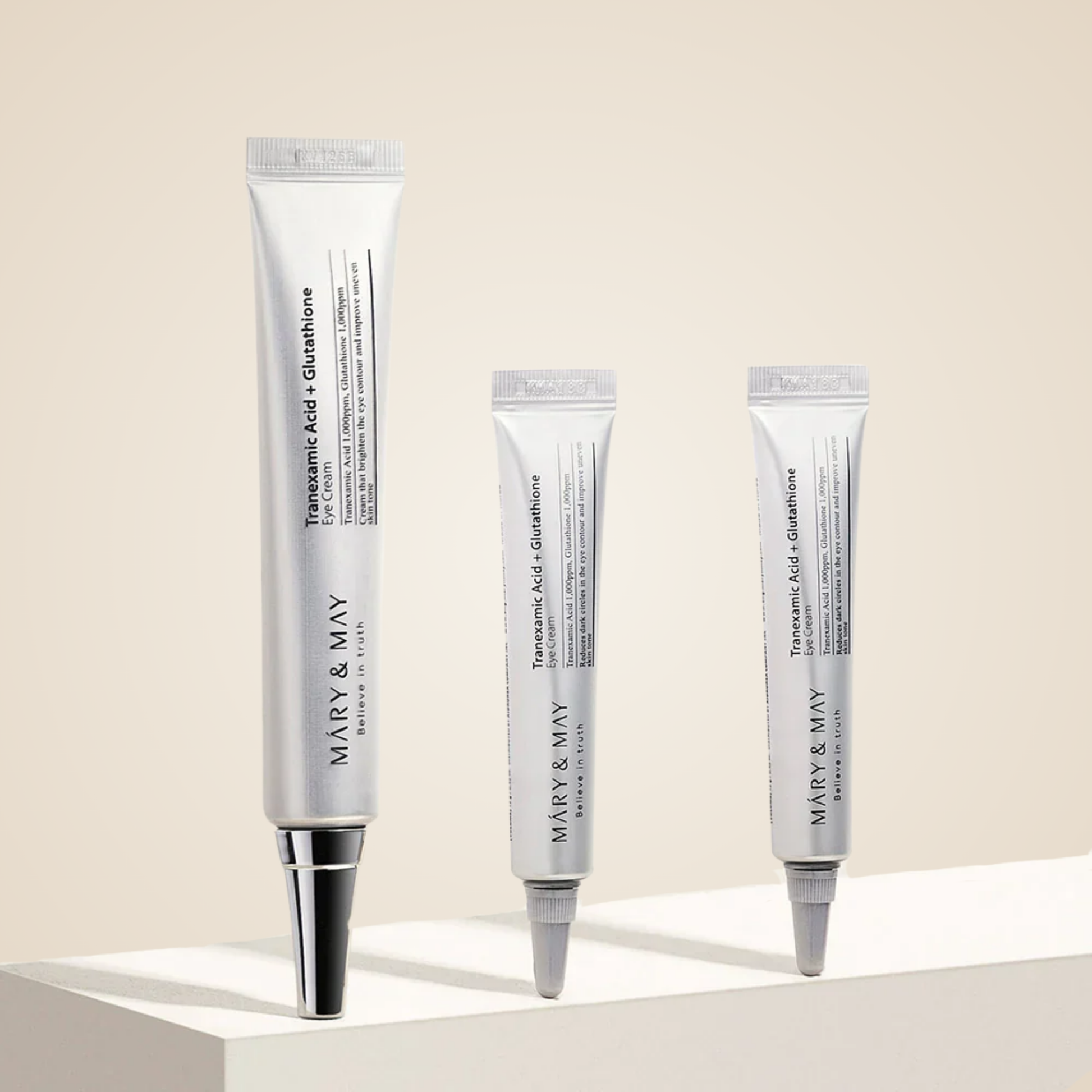 Mary & May Tranexamic Acid + Glutathione Eye Cream tubes displayed together on minimalist platform