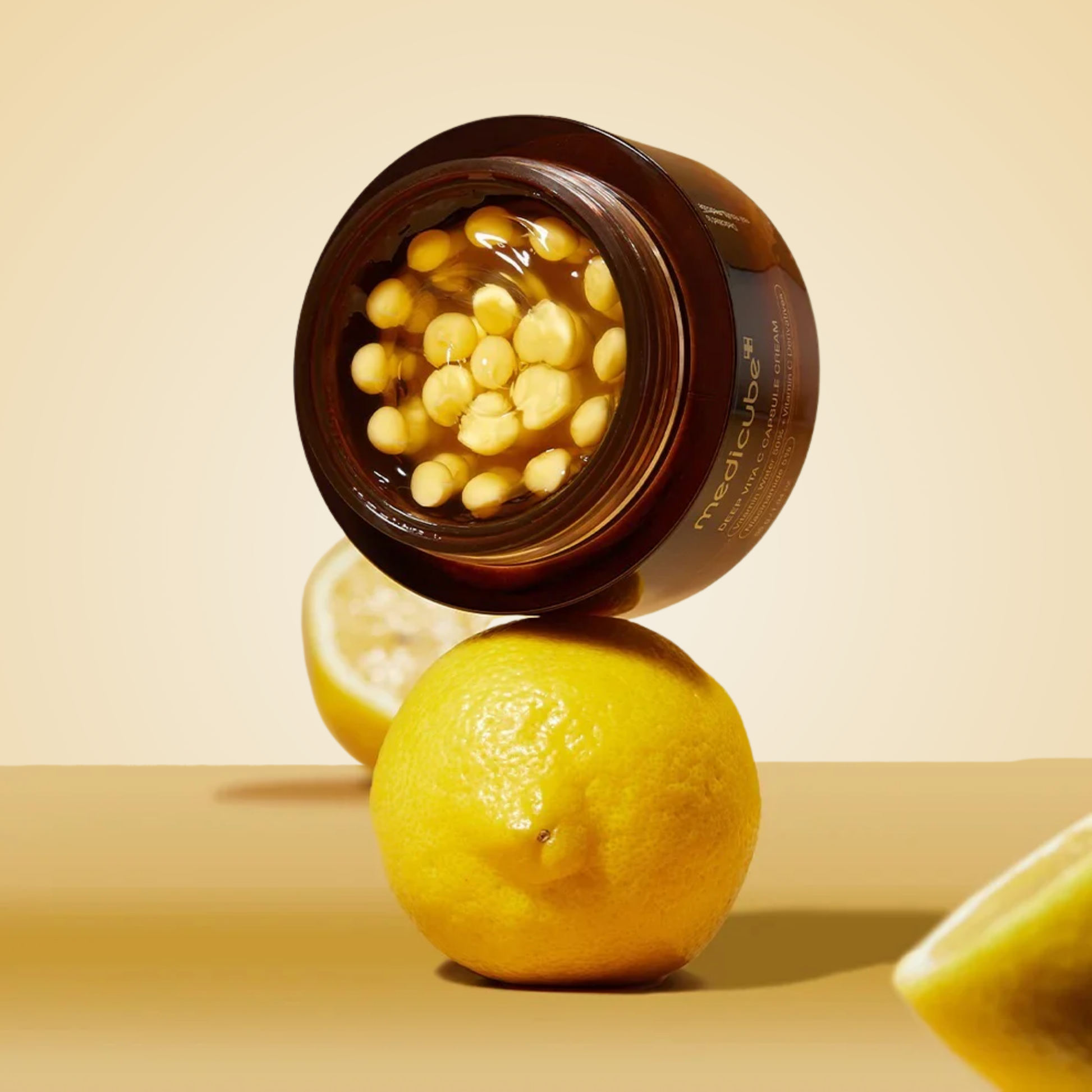 medicube Deep Vita C Capsule Cream 55g with lemon fruit, symbolizing vitamin C glow.