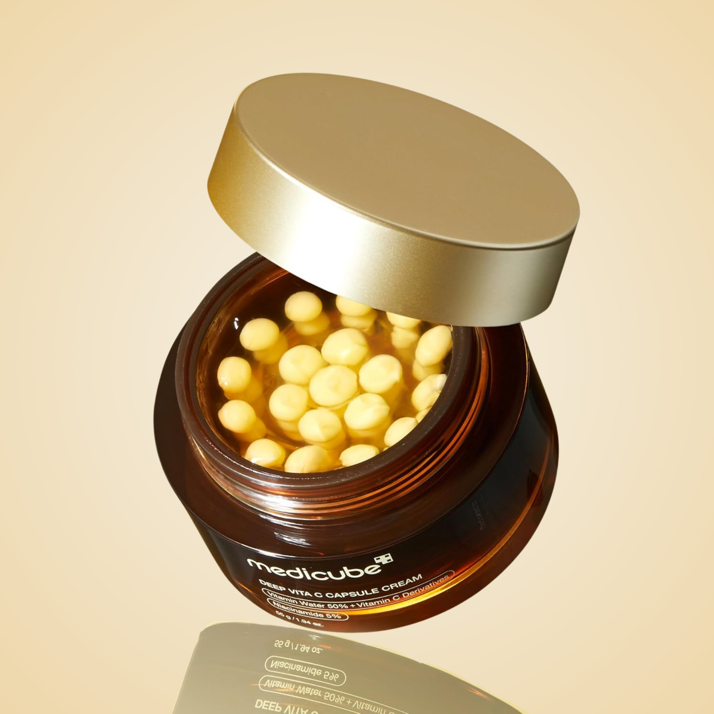 Tilted jar of medicube Deep Vita C Capsule Cream highlighting vitamin C beads inside.