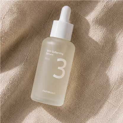 Numbuzin No.3 Skin Softening Serum 50ml styled on a travertine vanity with beige linen, ceramic bowl, glass vase, and soft botanical shadows.