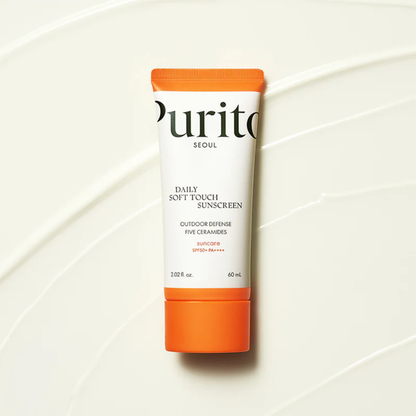 Purito SEOUL Daily Soft Touch Sunscreen SPF50+ PA++++ flatlay on smooth cream texture background