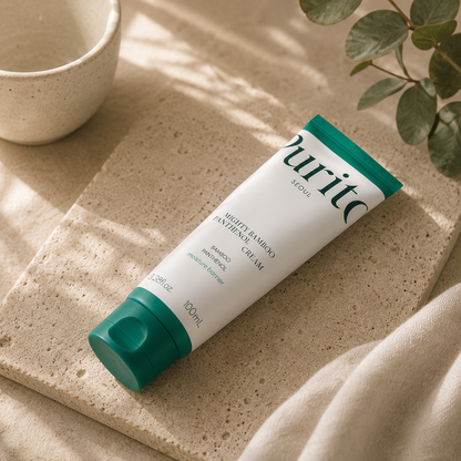 Purito SEOUL Mighty Bamboo Panthenol Cream 100ml resting naturally on a warm beige travertine stone slab with realistic contact shadows, styled with folded linen, a matte ceramic cup, and eucalyptus in soft morning sunlight for a luxury Korean skincare ritual editorial aesthetic.