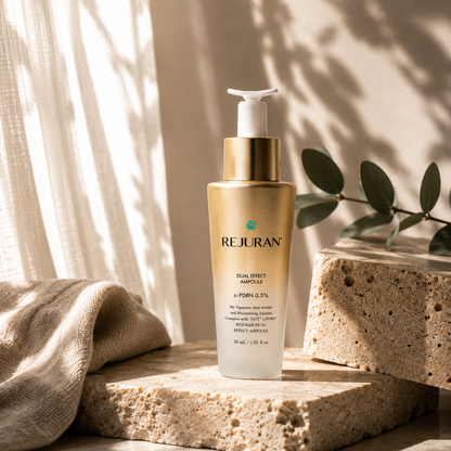 REJURAN Healer Turnover Ampoule Dual Effect PDRN 30ml naturally placed on a travertine tray with folded beige linen, ceramic cup, and eucalyptus in a calming Korean skincare ritual scene.