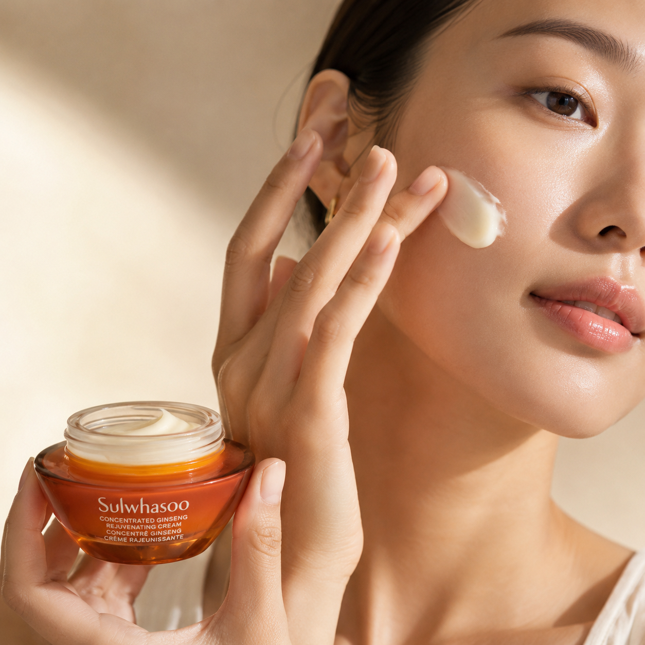 Sulwhasoo Concentrated Ginseng Rejuvenating Cream being applied onto the cheek, showing the rich cream texture in a soft natural skincare routine moment.