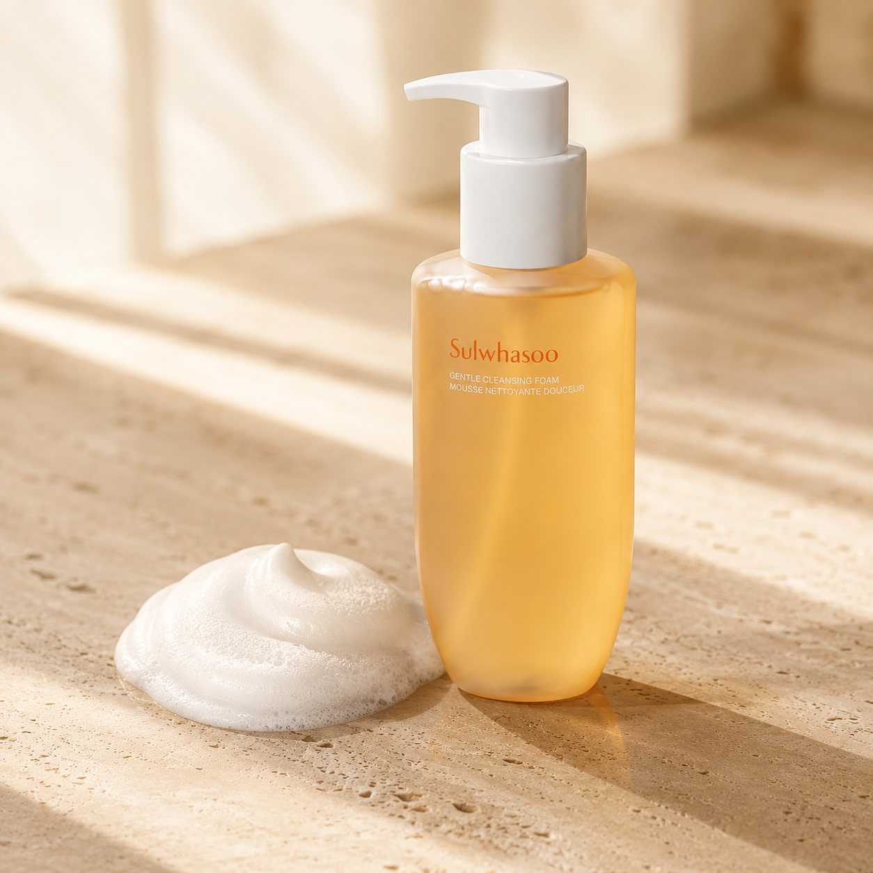 Sulwhasoo Gentle Cleansing Foam 200ml beside a soft white foam texture on warm travertine, highlighting its creamy cleansing formula in a luxury skincare editorial photo.