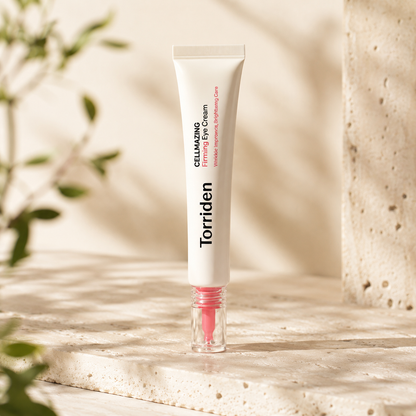 Torriden Cellmazing Firming Eye Cream 30ml displayed upright on warm travertine with soft morning sunlight in a premium Korean skincare hero photo.