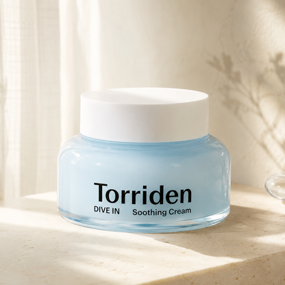 Torriden Dive-In Hyaluronic Acid Soothing Cream 100ml displayed on warm travertine with soft morning light in a premium Korean skincare hero photo.